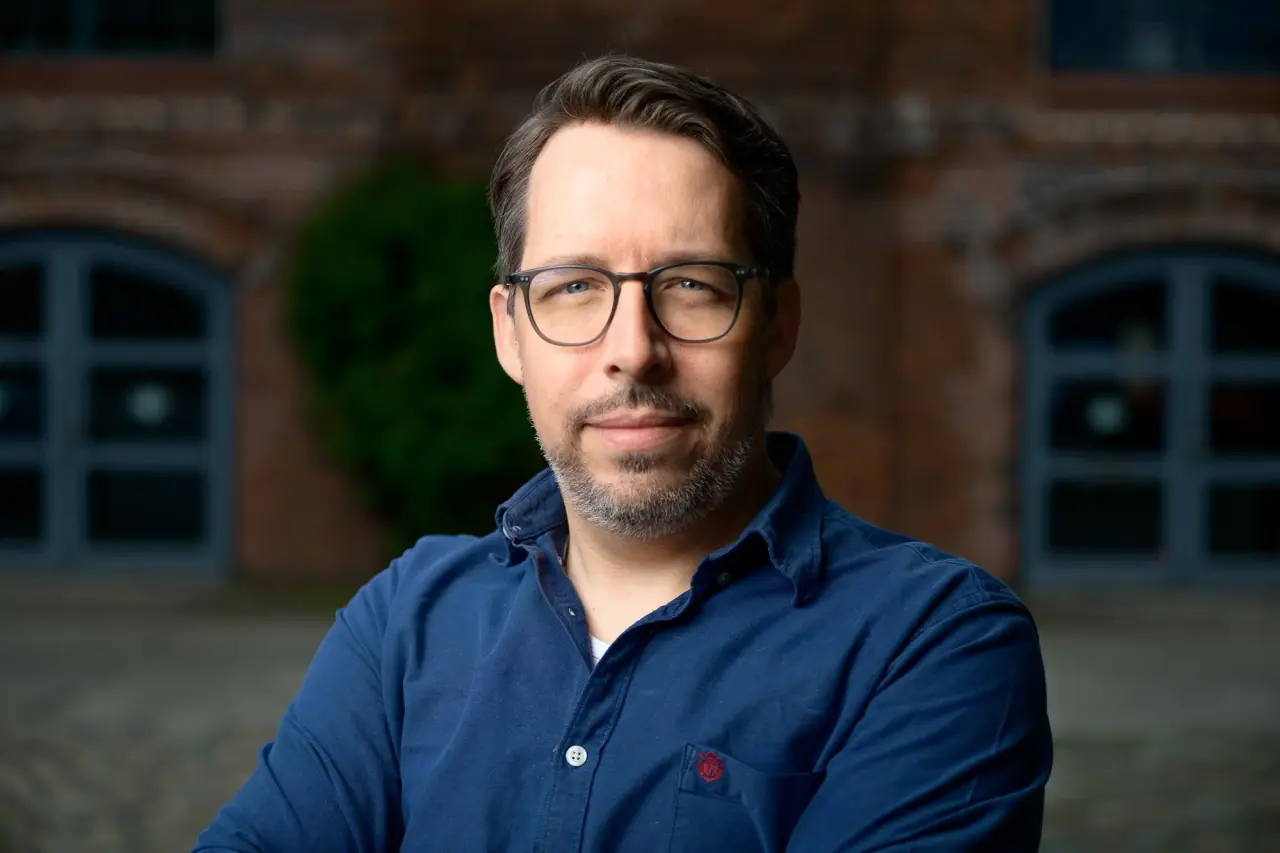 Portrait of Eric Horstmann, founder of Immersive Lab, in front of the studio building in Berlin-Buch.